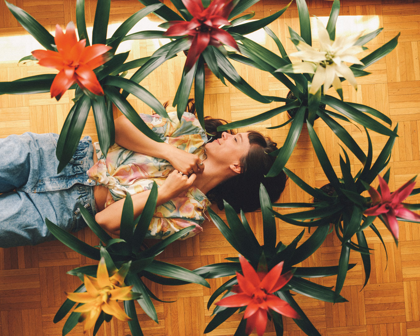 Frau liegt auf Boden mit Blumen Pflanzen Bromelien
