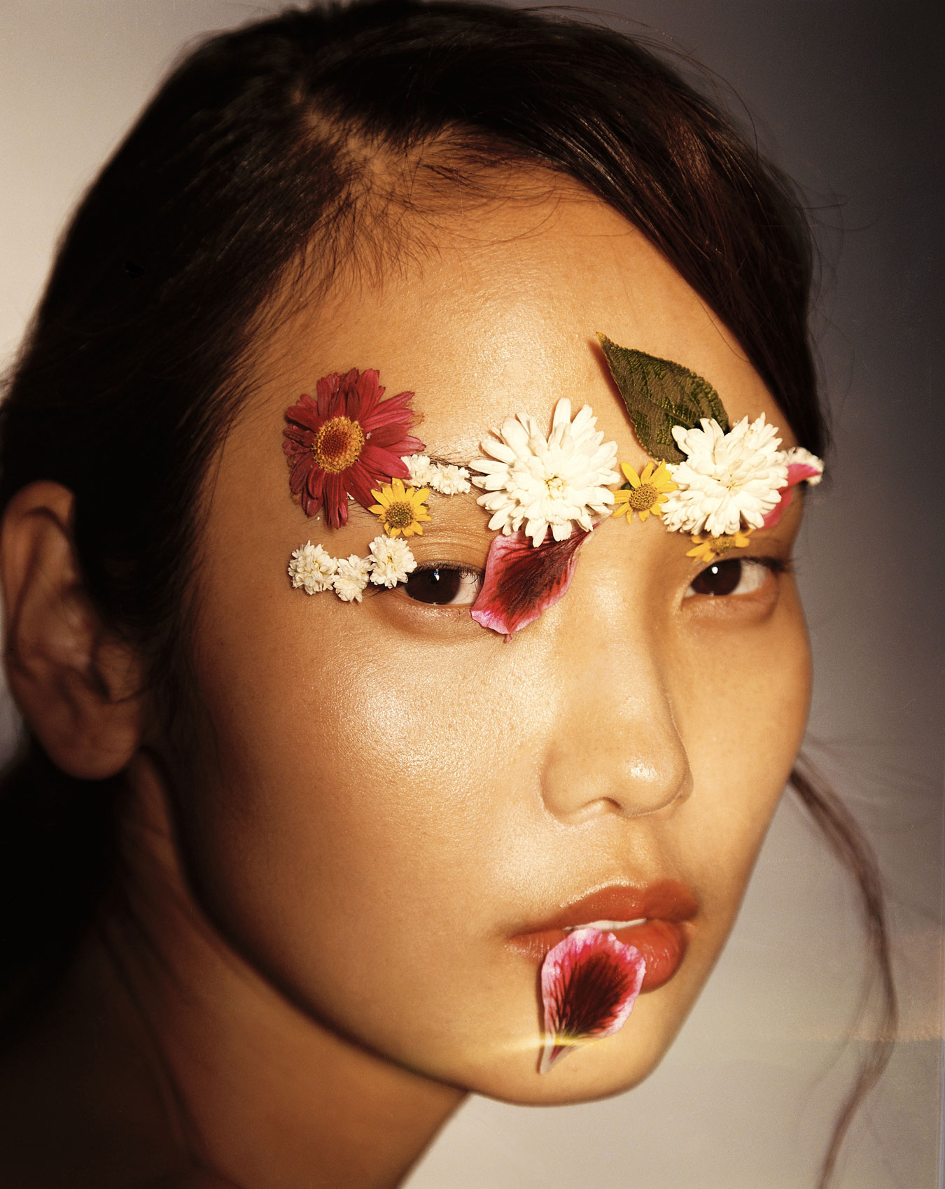 Clean Beauty Frau mit Blumenblüten im Gesicht