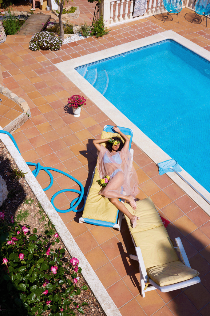 eine Frau im Bikini auf einer Liege am Pool